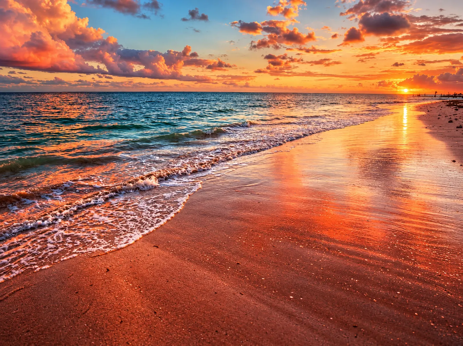 A warm sunset reflected on a wet shoreline